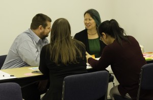 A small breakout group works on a case study idea. 